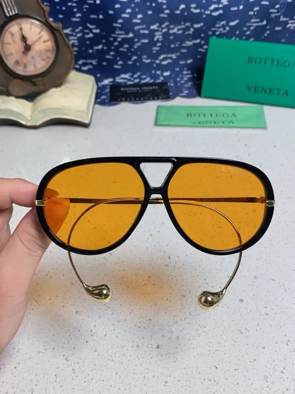 Bottega Veneta Black Frame Sunglasses with Amber Lenses and Gold Temples